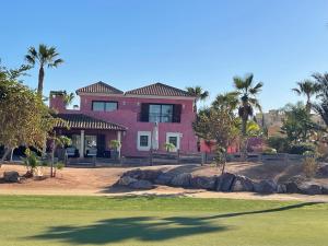 a pink house with palm trees in front of it at Casa Indalo in Cuevas del Almanzora