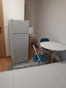 eine Küche mit einem Kühlschrank sowie einem Tisch und Stühlen in der Unterkunft levinja in Izola