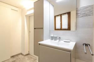 ein weißes Badezimmer mit einem Waschbecken und einem Spiegel in der Unterkunft Belle Arti loft, in the heart of the city in Bologna
