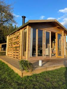 een houten hut met glazen deuren op een terras bij The Deer Hut at Carr House Farm in Scarborough