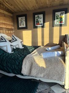 a bed in a room with pictures on the wall at The Deer Hut at Carr House Farm in Scarborough