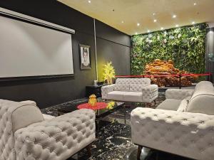 a living room with white chairs and a projection screen at The Artz Hotel in Genting Highlands