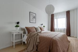 a white bedroom with a bed and a window at Urban Oasis on Sodermalm, Sleeps Six in Stockholm