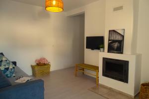 a living room with a couch and a fireplace at CASA DO TOMILHO by Stay in Alentejo in Vila Nova de Milfontes