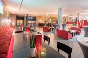 a restaurant with red chairs and tables in a lobby at Abba Berlin Hotel in Berlin