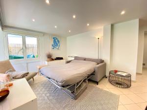 duża sypialnia z łóżkiem i kanapą w obiekcie Les Jardins de Lérins By SCLS Locations w Cannes