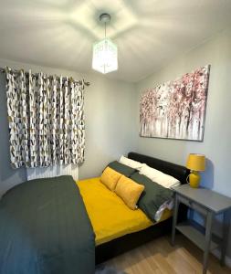 um quarto com uma cama, uma mesa e um quadro em Large Cosy 2 bedroom Apartment in Stevenage SG1 Sleeps 5 em Stevenage