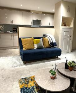 uma sala de estar com um sofá azul e duas mesas em Large Cosy 2 bedroom Apartment in Stevenage SG1 Sleeps 5 em Stevenage