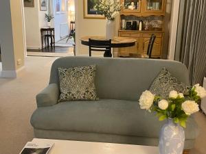 una sala de estar con sofá y un jarrón de flores en Castlecroft Bed and Breakfast en Stirling