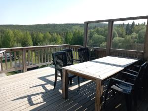 una terraza de madera con mesa y sillas. en Ristafallet, en Åre