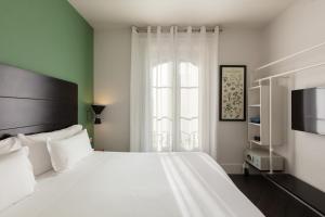 Un dormitorio con una gran cama blanca y una ventana en Praktik Garden, en Barcelona