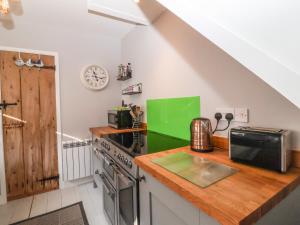 a kitchen with a stove and a counter top at Secret Cottage, Southwold in Southwold