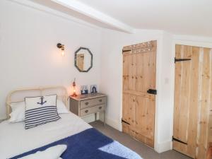 a bedroom with a bed and a wooden door at Secret Cottage, Southwold in Southwold