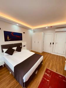 a bedroom with a large white bed and a red rug at Hodegon Suite Hotel in Istanbul