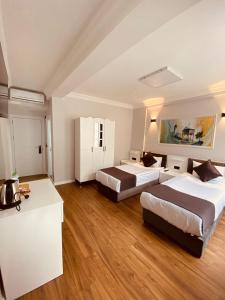 um quarto de hotel com duas camas e uma cozinha em Hodegon Suite Hotel em Istambul