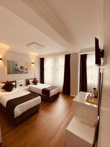 um quarto de hotel com duas camas e um sofá em Hodegon Suite Hotel em Istambul