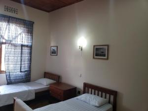 a room with two twin beds and a window at Mahali Muzuri, Arusha in Arusha