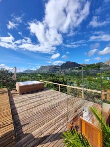 a deck with a bed and a view of mountains at Euetu na Lapinha da Serra in Santana do Riacho