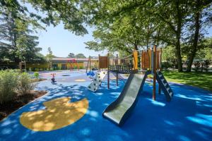 a playground with a slide in a park at SUNNY Mobile Homes Bijela Uvala in Poreč