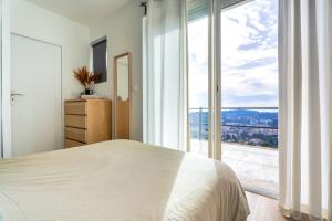 ein Schlafzimmer mit einem Bett und einem großen Fenster in der Unterkunft Appartement avec vue mer panoramique in Toulon