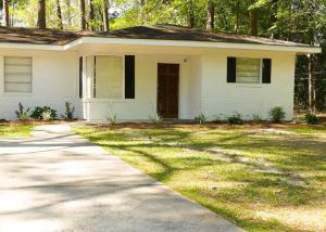 a white house with a driveway at Comfortable Cottage on the Blue Mile - Close to GSU! in Statesboro