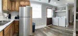 een keuken met een roestvrijstalen koelkast en houten kasten bij Amazing Cottage - Located on Blue Mile - Close to GSU! in Statesboro
