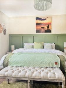 1 dormitorio con 1 cama grande y cabecero verde en The Starlings Country House en Wexford