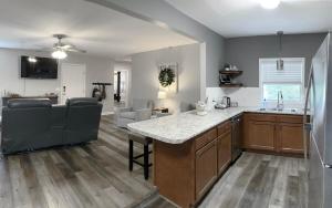 a kitchen and living room with a sink and a counter at The Cottage House on the Blue Mile - Family Friendly, Close to GSU! in Statesboro