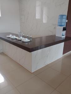 a counter with plates and wine glasses on it at pousada Gostoso Paradise in São Miguel do Gostoso
