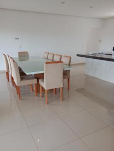 a dining room with a glass table and chairs at pousada Gostoso Paradise in São Miguel do Gostoso