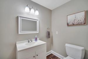 a white bathroom with a sink and a toilet at Downtown Loft - Above Bull & Barrel & Close to Georgia Southern in Statesboro +30 photos