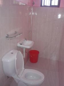 Baño blanco con aseo y lavamanos en Pabua's Cottages, en Mambajao