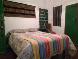 una camera da letto con un letto con una coperta colorata di Country House Chulumani a Chulumani