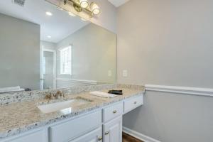 a bathroom with a sink and a large mirror at Eagle's Nest - Spacious Loft Downtown - Near GSU in Statesboro