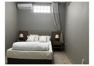 Matola的住宿－Chonguile Villa 1 Modern Minimalist in Matola，一间卧室配有带白色床单和枕头的床。