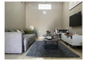 - un salon avec un canapé et une table dans l'établissement Chonguile Villa 1 Modern Minimalist in Matola, à Matola