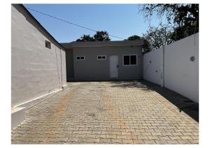 a garage with two doors and a brick driveway at Chonguile Villa 1 Modern Minimalist in Matola in Matola