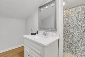 a white bathroom with a sink and a mirror at Eagle Creek Loft - Close to Shops Food GSU in Statesboro