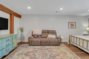 a living room with a brown couch and a tv at The Post Suite - above Bull & Barrel Close to GSU in Statesboro