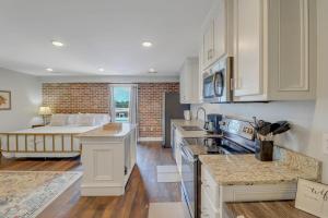a kitchen with white cabinets and a living room at The Post Suite - above Bull & Barrel Close to GSU in Statesboro