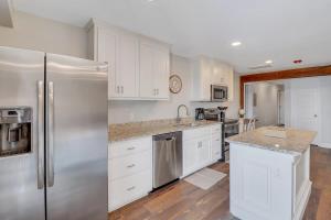 a kitchen with white cabinets and stainless steel appliances at The Post Suite - above Bull & Barrel Close to GSU in Statesboro