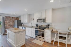 a kitchen with white cabinets and a stove top oven at The Post Suite - above Bull & Barrel Close to GSU in Statesboro