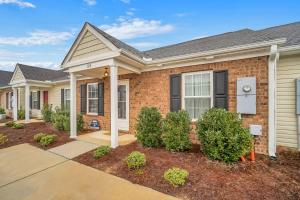 une maison en briques avec des buissons devant elle dans l'établissement GATA Suite - Quiet neighborhood 10 minutes to GSU, à Statesboro