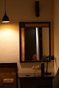 a bathroom with a mirror and a sink and a lamp at Red Panda Jungle Camp - A Unit of Davinchi Homes Pvt Ltd in Gyalzing