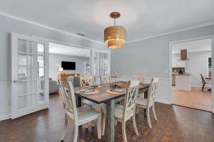 een eetkamer en een woonkamer met een tafel en stoelen bij Southern Splash Retreat Poolside Paradise by GSU in Statesboro