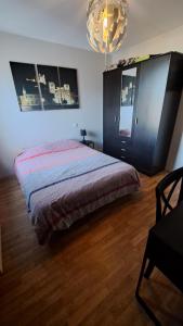 1 dormitorio con cama y lámpara de araña en Appartement cosy 3 pièces avec garage privatif, en Saint-Priest