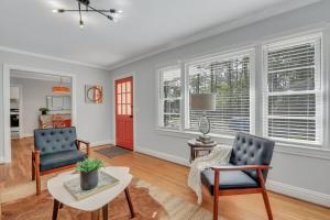 a living room with two chairs and a table at Mid-Century Bungalow - Blue Mile & Close to GSU in Statesboro