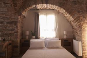 a bedroom with a bed and a window at enδόtera chios apartments in Chios