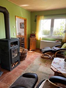 a living room with a wood burning stove in it at Idyllisches Gartenhaus 