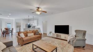 a living room with a couch and a flat screen tv at Eagle's Retreat - Close to GSU & Paulson Stadium in Statesboro